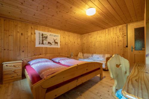 a bedroom with a bed in a wooden room at Obere Roner Kasa in Mörtschach