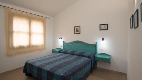Un dormitorio con una cama verde y una ventana en Welcomely - Stella Marina Blu, en Cala Liberotto