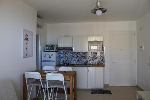 eine Küche mit Tisch und Stühlen in einem Zimmer in der Unterkunft Casa CostaSud in Marina di Ragusa