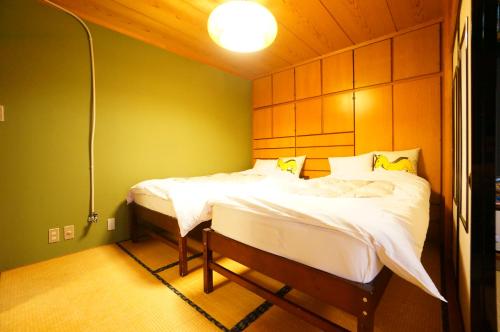 sypialnia z 2 łóżkami w pokoju w obiekcie Tomato House Takayama w mieście Takayama