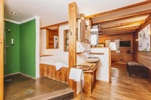 uma casa de banho com uma banheira e uma parede verde em Roanwirt em Sankt Lorenzen im Mürztal