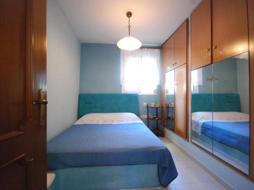 a bedroom with a blue bed and a window at Tenedos Home by TravelPro Services Halkidiki in Néa Ténedhos