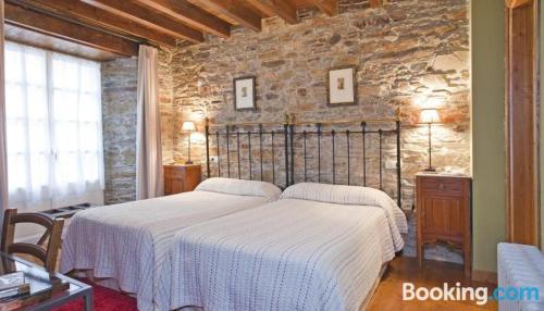 a bedroom with a bed and a stone wall at Casa Soto in Vegadeo