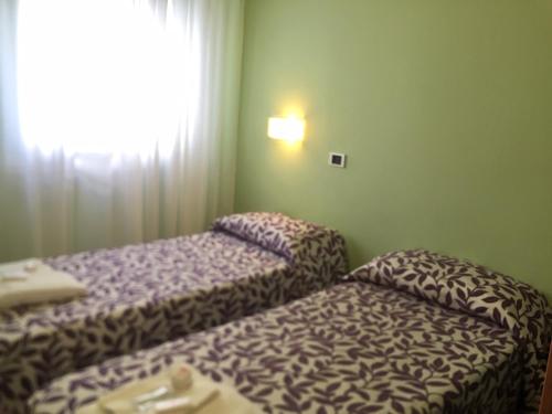 two beds sitting in a room with a window at Hotel La Rosa Dei Venti in Albinia
