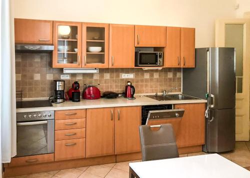 La cuisine est équipée d'armoires en bois et d'un réfrigérateur en acier inoxydable. dans l'établissement Karlova 22 - Old Town Apartment, à Prague