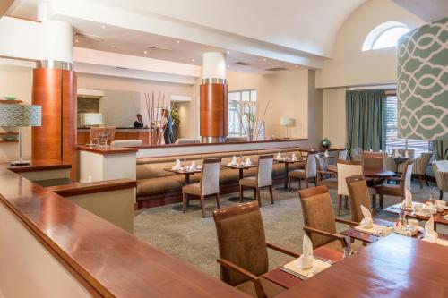 a restaurant with tables and chairs and a bar at Town Lodge Roodepoort in Roodepoort