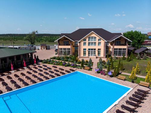 a large house with a blue swimming pool in front of it at Villa San Marino in Vorzelʼ