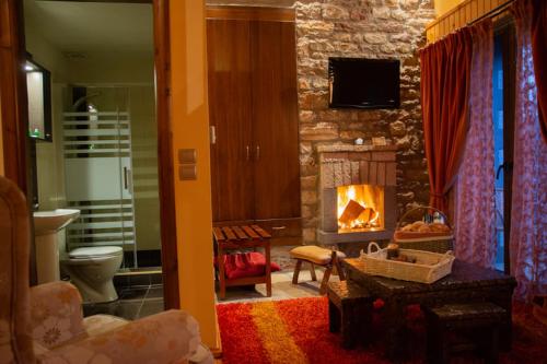 a living room with a fireplace and a stone wall at Sokaki in Méga Khoríon