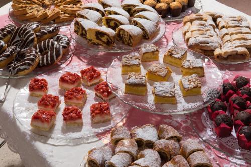 a table filled with different types of pastries and desserts at Residence San Giusto in Trieste