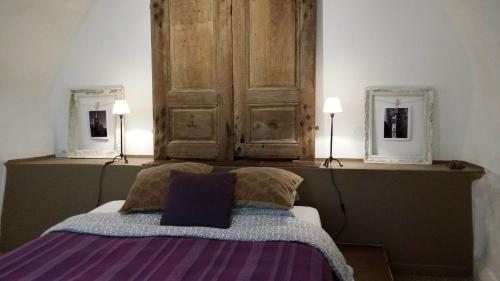 a bedroom with a bed with two mirrors on the wall at Olivenhuset in Fons-sur-Lussan