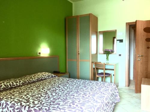 a bedroom with a bed and a table with a chair at Hotel La Rosa Dei Venti in Albinia