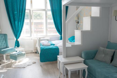 a living room with a blue couch and a bed at Old Town Square Apartment Novi Sad in Novi Sad