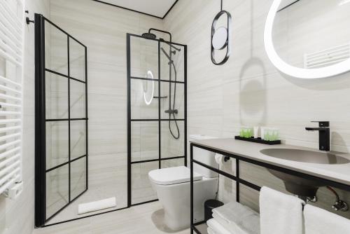 a bathroom with a toilet and a sink and a mirror at Smartrental Collection Gran Vía Centric in Madrid