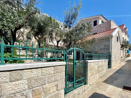 a green gate in front of a stone wall at Waterview Apartments - Koru Apartment and pool in Mimice