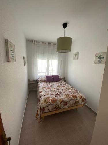 a bedroom with a bed in a room with a window at Unter den Linden in Comarruga