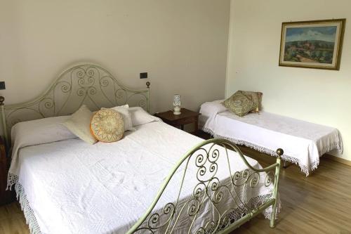 a bedroom with two beds with white sheets at Agriturismo La Collina Toscana in Pieve a Maiano