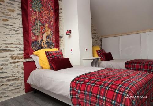 um quarto com 2 camas com almofadas vermelhas e amarelas em Mon Savoureux Jardin em Challain-la-Potherie