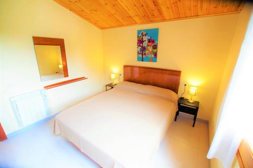 1 dormitorio con cama blanca y espejo en V&V LLORET - VILLA CANYELLES preciosa villa para 8PAX con piscina privada y barbacoa a solo 800m de playa Cala Canyelles, en Lloret de Mar
