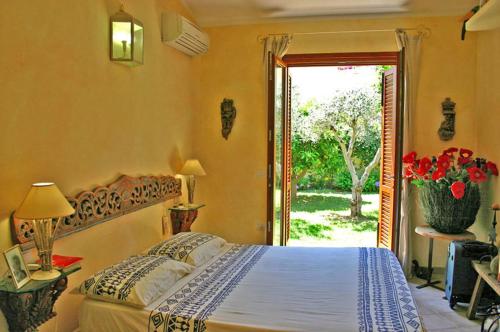 1 dormitorio con 1 cama y puerta a un patio en Villetta Liccia, en Palau