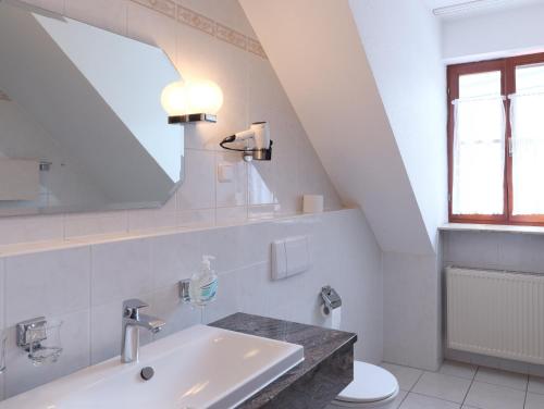 a white bathroom with a sink and a mirror at Michels Stern in Marktbreit