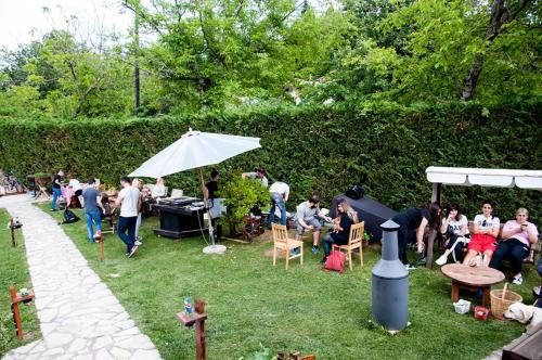 a group of people sitting in a yard with an umbrella at Kedra Village in Kédra