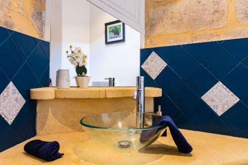 een badkamer met een glazen wastafel op een aanrecht bij La Ritournelle in Sarlat-la-Canéda