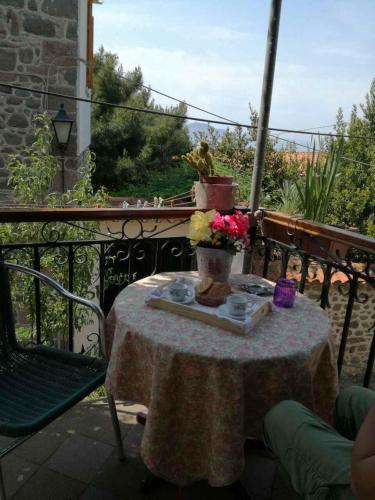 a table with a flower arrangement on a balcony at ΜΑΧΗ Ενοικιαζόμενα δωμάτια in Mithymna