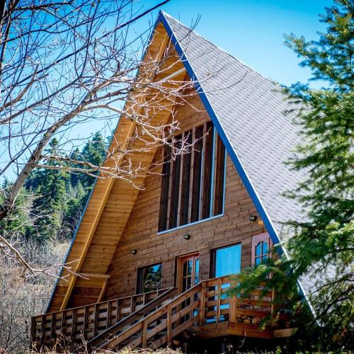a log cabin with a steep roof and a porch at Kedra Village in Kédra