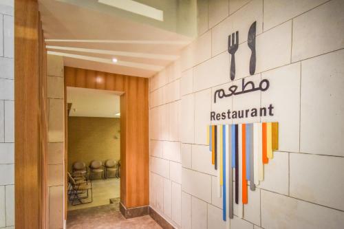 a restaurant sign on a wall with utensils at Ewaa Express Hotel - Khurais in Riyadh