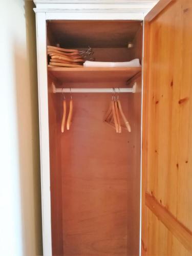 a closet with a wooden door and some umbrellas at affittacamere la loggia in Levanto