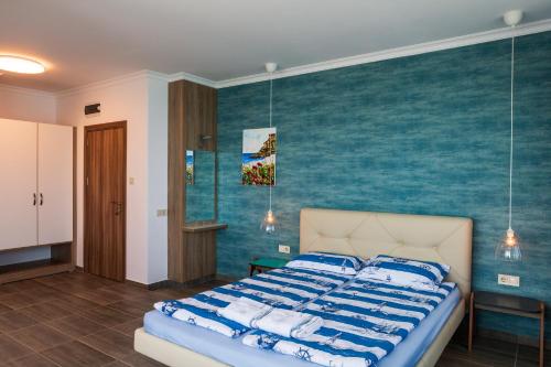 a bedroom with a bed with a blue wall at Villa Flora in Sozopol