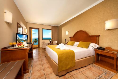 a hotel room with a bed and a desk at Hotel IPV Palace & Spa - Adults Recommended in Fuengirola