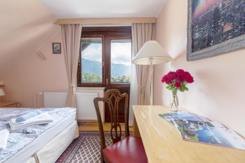 a bedroom with a table with a vase of flowers on it at Apartment Jakovc in Bohinj