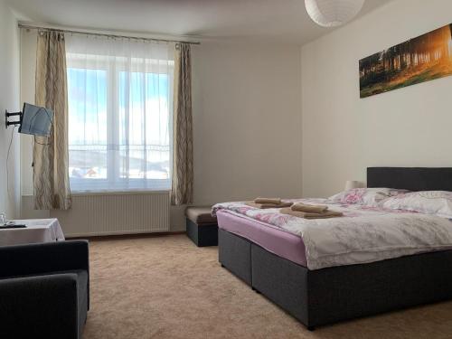 um quarto com uma cama grande e uma janela em Ubytovanie Violet em Važec