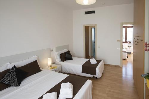 a bedroom with two beds and a living room at Casa Al Carmine in Padova