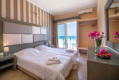 a bedroom with a bed and a view of the ocean at Aktypis Beachfront Studios in Laganas