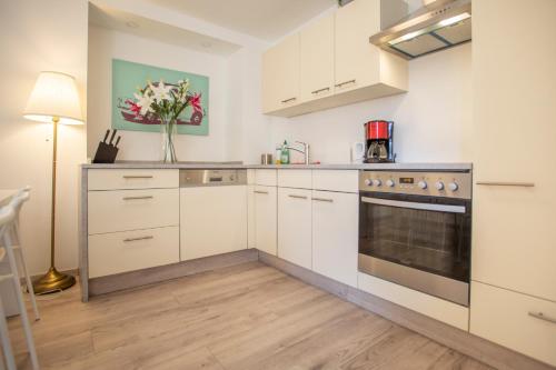 uma cozinha com armários brancos e um fogão em City Center Apartment em Innsbruck