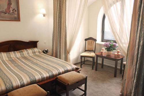 a hotel room with a bed and a chair and a table at Гранде Петтине in Odesa