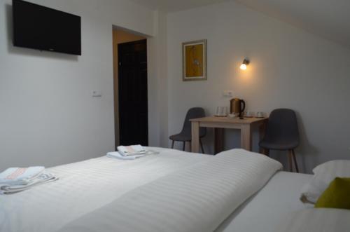 a bedroom with two beds and a table with chairs at Katarica in Korenica