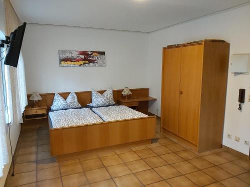 - une chambre avec un lit et une armoire en bois dans l'établissement Auf dem roten Fels, à Eppenbrunn
