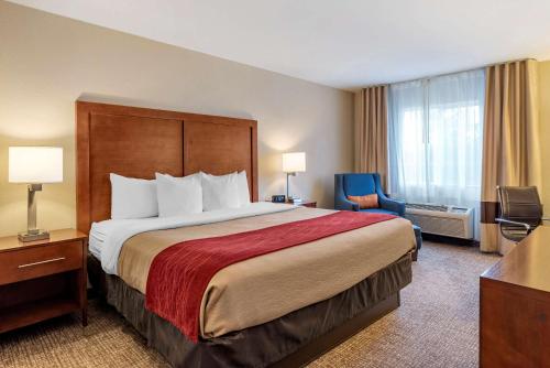 um quarto de hotel com uma cama grande e uma cadeira em Comfort Inn & Suites Klamath Falls em Klamath Falls