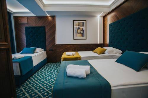 um quarto com duas camas e um banco em Hotel Jelena Brčko em Brcko