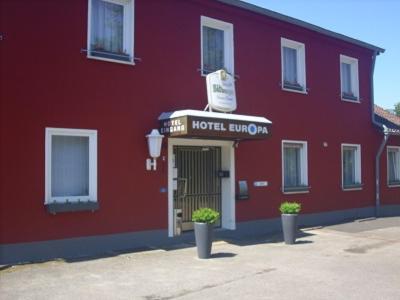 a red building with a hotel sign on top of it at Hotel Europa in Holsthum