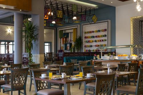 a dining room with wooden tables and chairs at Ali Baba Palace Resort in Hurghada