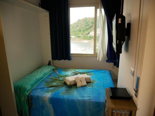 - une chambre avec un lit et des serviettes dans l'établissement Mare Roccia beachfront apartment, à Taormine