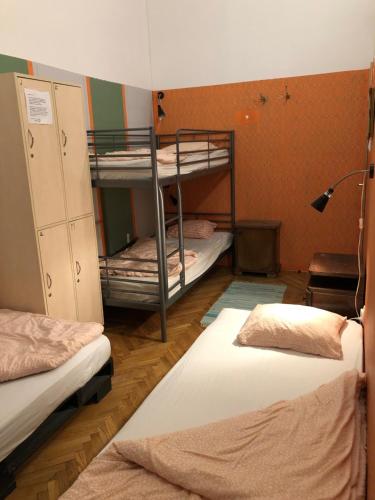 a room with three bunk beds and a lamp at Baroque Hostel & Coworking in Budapest