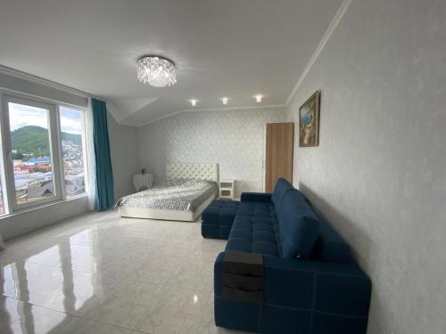 オリギンカにあるАпартаменты "Морские Люкс"のリビングルーム(青いソファ、ベッド付)