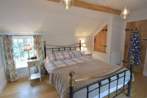 a bedroom with a large bed and a window at Brook Cottage - Luxury in Mundesley in Mundesley