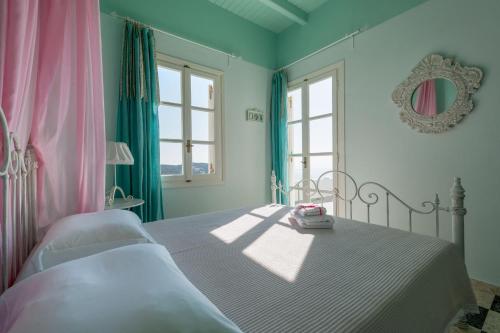 a bedroom with a bed with pink and green walls at Kimolian Houses in Kimolos