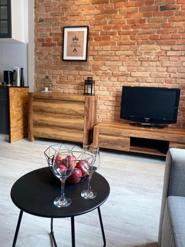een woonkamer met een tafel met twee wijnglazen bij Apartamenty ToTuGdynia 7 in Gdynia